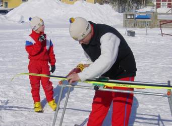 Erik Andersson borstar skidor och Eric Lundqvist ser p.